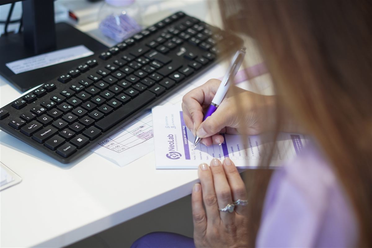 En la recepción, una persona completa un formulario junto al teclado.