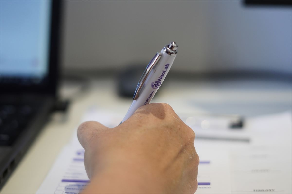 Una mano completa a mano un formulario de NeoLab.
